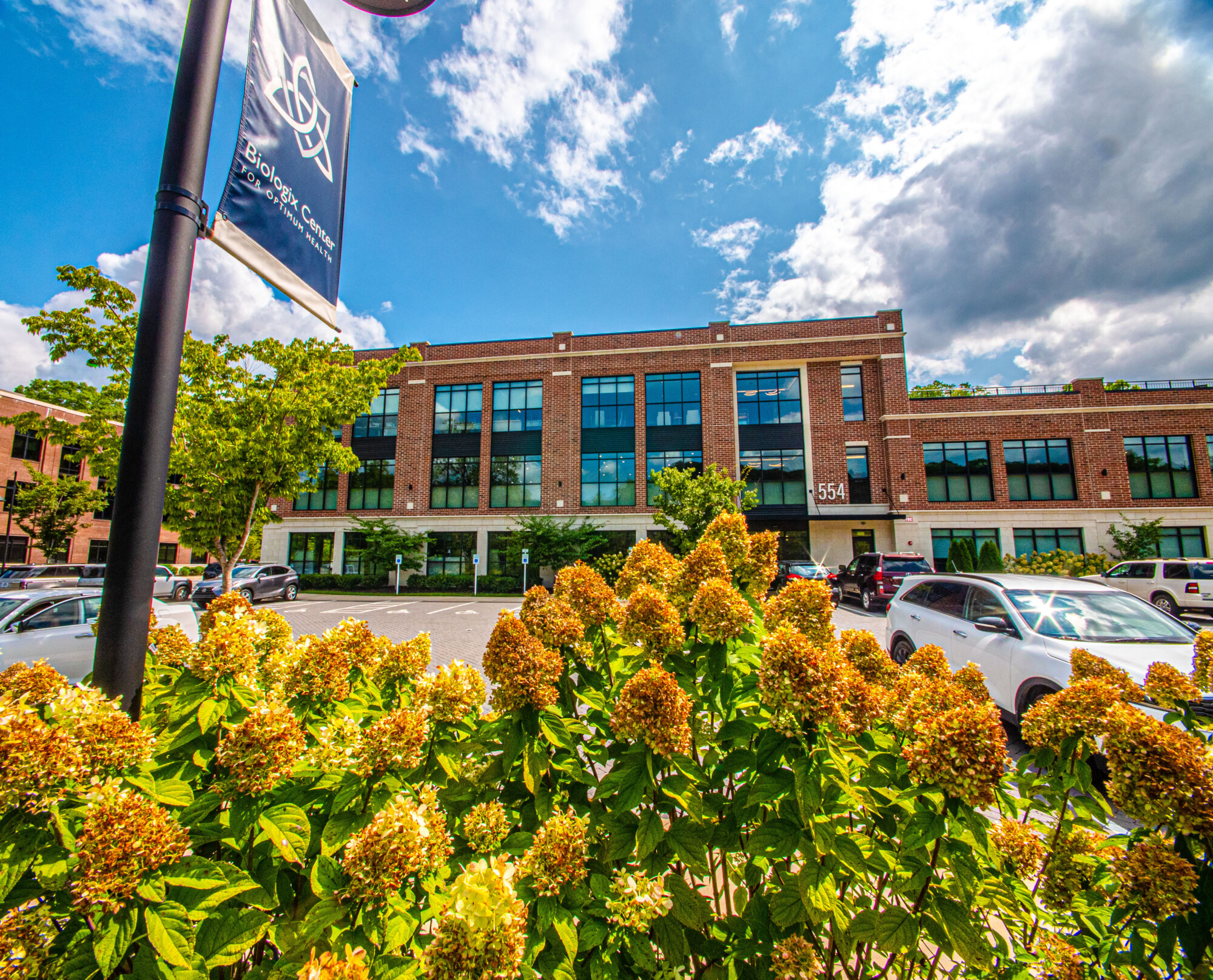 Exterior view of the Biologix Center for Optimum Health building in Franklin, Tennessee, with flowering plants in the foreground.